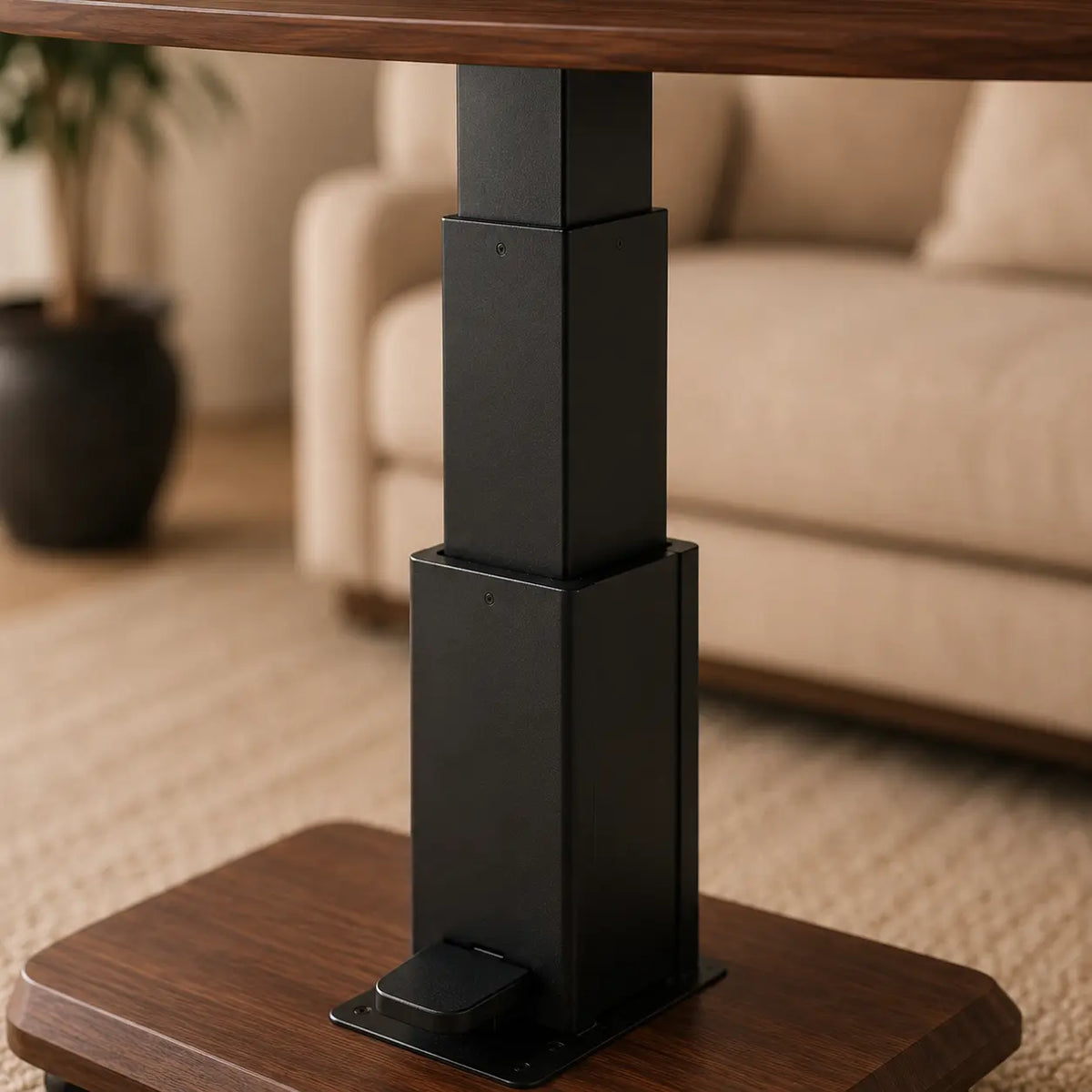 A close-up of a black adjustable table pedestal base with a wood-look top and matching wood-look tabletop, shown in a softly blurred living room setting with a sofa and plant in the background.