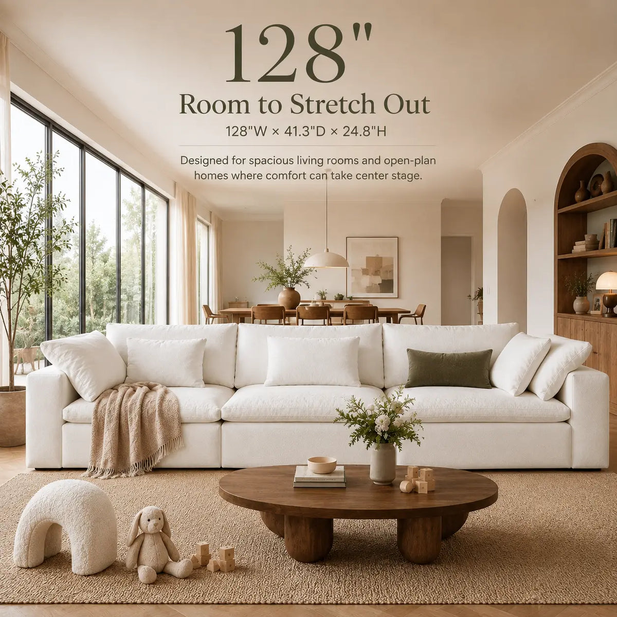A large white room-stretching sectional sofa in a bright, modern living room. Text at the top reads '128" Room to Stretch Out' with dimensions and a note about spacious living rooms and open-plan homes.